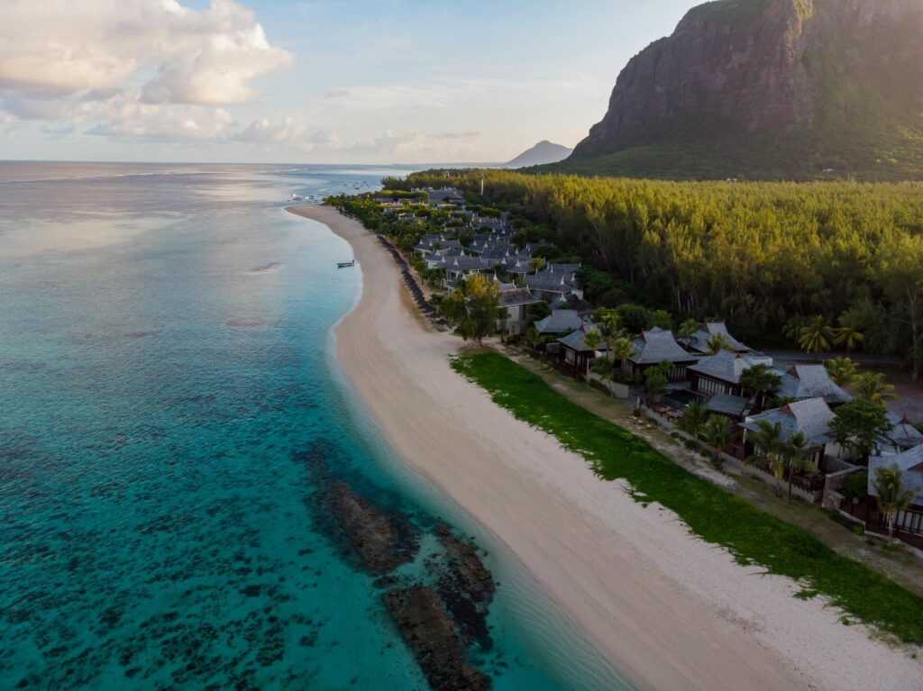 Aerial photograph of a tranquil beach resort in Mauritius with clear waters and lush greenery.